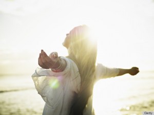 Teenage girl with arms outstretched at sunset